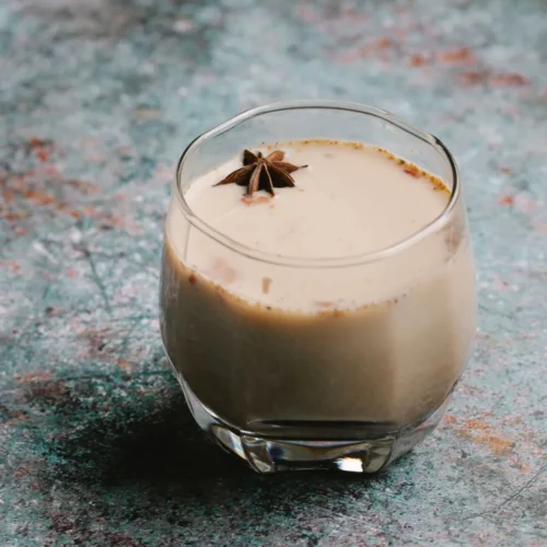 Chai latte w szklance z gwiazdką anyżu na piance